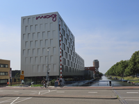 901876 Gezicht op het onlangs geopende Moxy Hotel (Helling 1) te Utrecht, vanaf de Vondelbrug over de Vaartsche Rijn.